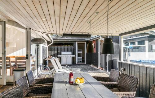 a wooden table on a balcony with chairs and a table at Three-Bedroom Holiday Home In Vaggerlose in Marielyst