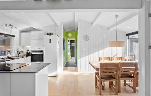 a kitchen and dining room with a table and chairs at Three-Bedroom Holiday Home In Vaggerlose in Marielyst