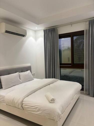 un lit blanc dans une chambre avec une fenêtre dans l'établissement Hawana Salalah Resort - SL 2, à Salalah