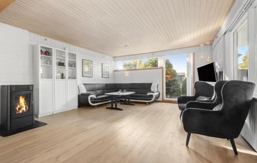 a living room with couches and a fireplace at Holiday Home Birkevej Ebeltoft Ii in Øksenmølle