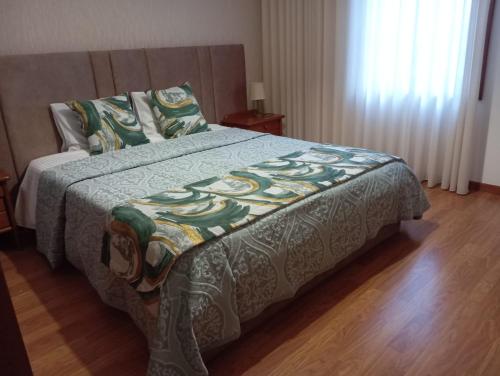 een slaapkamer met een bed met een deken erop bij Varandas do Tamega in Mondim de Basto