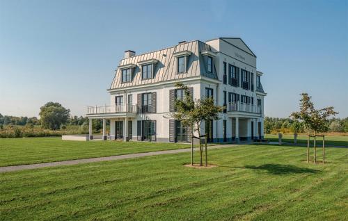 a large white house on a grass field at Cozy Apartment In Kamperland With Wifi in Kamperland