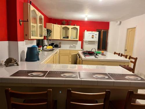 a kitchen with red walls and a table with chairs at Kasa Mar in Puerto Villamil