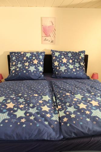 a bed with blue comforter with stars on it at Apartment Haus Sternenhimmel in Lehmrade