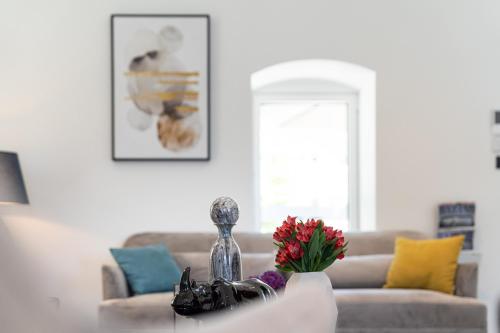 a living room with a couch and a table with flowers at Villa Lastva in Tivat