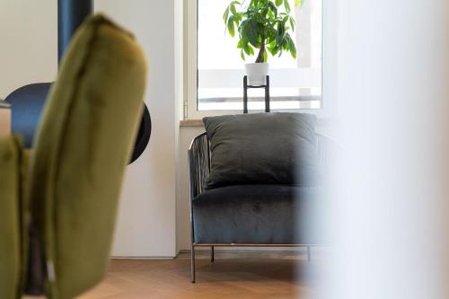 a green chair in a room with a potted plant at Villa Lastva in Tivat