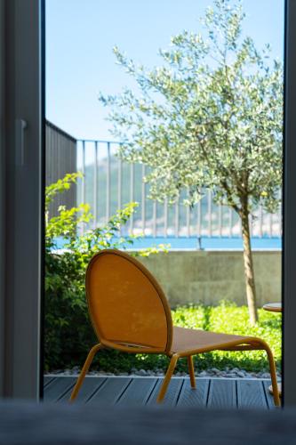 a wooden chair sitting in front of a window at Villa Lastva in Tivat