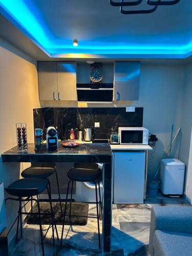 une cuisine avec un comptoir et des tabourets dans une pièce dans l'établissement The most beautiful studio, à Bagnolet