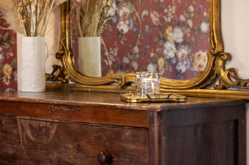 a mirror on a dresser with a glass on it at L’Aurora in Todi