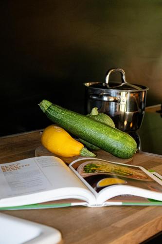 a book on a table with vegetables and a book at Tiny House Stijl & natuur nabij Brugge! in Beernem