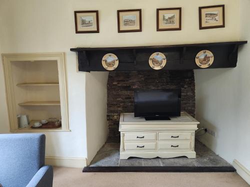 a living room with a tv on a fireplace at Langley Inn in Bristol