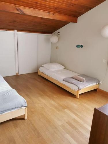 une chambre avec deux lits et un parquet dans l'établissement Maison au bord du lac, les pieds dans l'eau, à Soustons