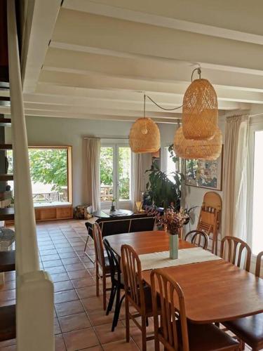 une cuisine et une salle à manger avec une table et des chaises dans l'établissement Maison au bord du lac, les pieds dans l'eau, à Soustons