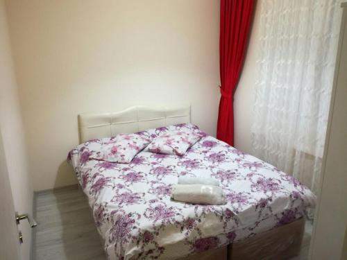 a small bedroom with a bed with a floral bedspread at Egepar Rezidance Apart otel in Buca