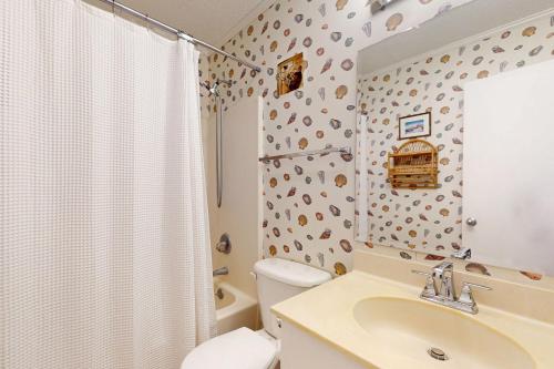 a bathroom with a toilet and a sink and a shower at Dunescape Villas 210 in Atlantic Beach