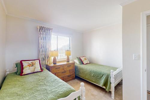 a bedroom with two twin beds and a window at Dunescape Villas 210 in Atlantic Beach