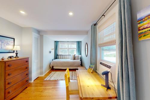 a bedroom with a bed and a desk and a window at Seabreeze Escape in Barnstable