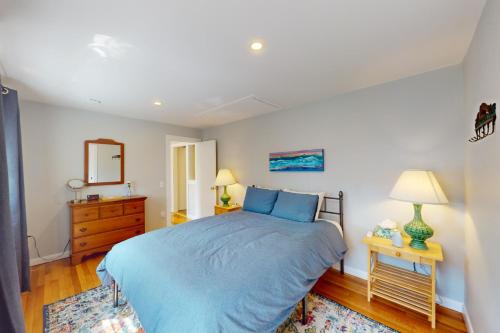 a bedroom with a bed and a dresser and a mirror at Seabreeze Escape in Barnstable