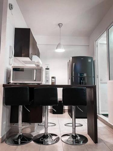 a kitchen with a counter with a microwave and a refrigerator at Depto Av Granjas Azcapotzalco in Mexico City