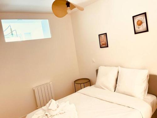 une chambre avec un lit avec des draps blancs et une fenêtre dans l'établissement Cosy loft- Paris 17e - 4 pers, à Paris
