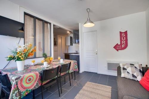 a dining room with a table with flowers on it at Appartement Mazagran - Welkeys in Biarritz
