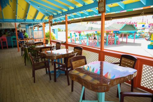 ein Restaurant mit Tischen und Stühlen und einen Vergnügungspark in der Unterkunft Graham's Place in Guanaja