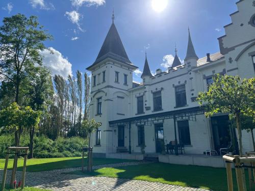 a large white building with towers on top of it at Vakantiewoning de Toren in Kortessem