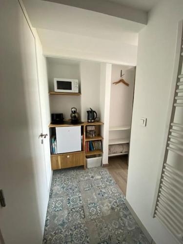 un couloir avec une chambre avec un four micro-ondes et une porte dans l'établissement Sea Lodge - Plage de Port Mer, Cancale, à Cancale