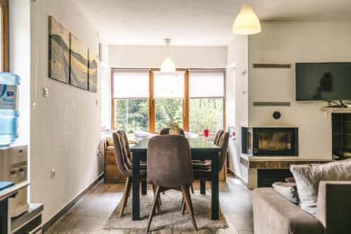 a dining room and living room with a table and chairs at Zeleni svet 2 in Crni Vrh