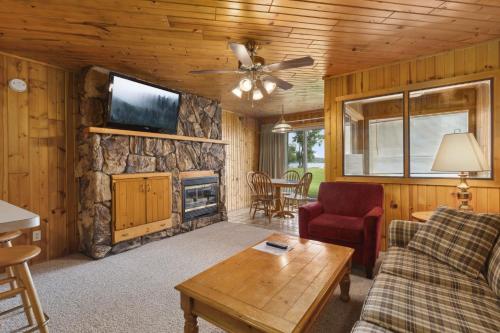 a living room with a couch and a tv and a fireplace at The Lodges at Breezy Point in Breezy Point