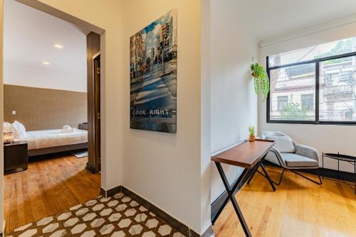 una sala de estar con una mesa y un sofá en Casona y Loft Merida By Escajal Homes, en Ciudad de México