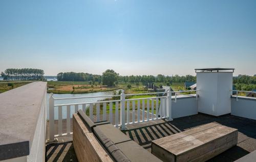 a balcony with a bench and a view of a river at Cozy Apartment In Kamperland in Kamperland