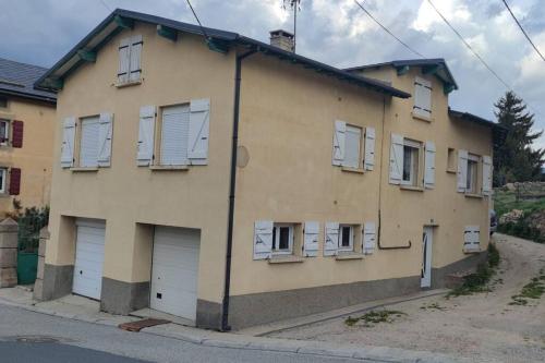 un bâtiment avec des portes et des fenêtres blanches sur une rue dans l'établissement Appartement montagne Saint Pierre Del Forcats, à Saint-Pierre-dels-Forcats