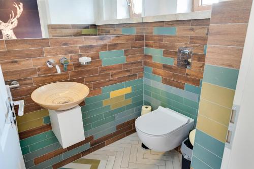 a bathroom with a toilet and a tiled wall at Design Apartment Villa Anna Kitzbühel in Kitzbühel