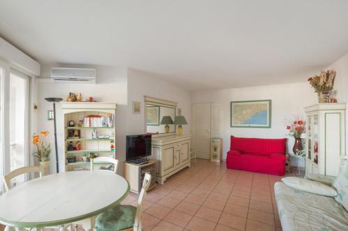 un salon avec un canapé rouge et une table dans l'établissement Appartement Lanterne Welkeys, à Nice