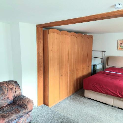 a bedroom with a bed with a red bedspread at Gasthof Oberschmiede in Auf der Wiese