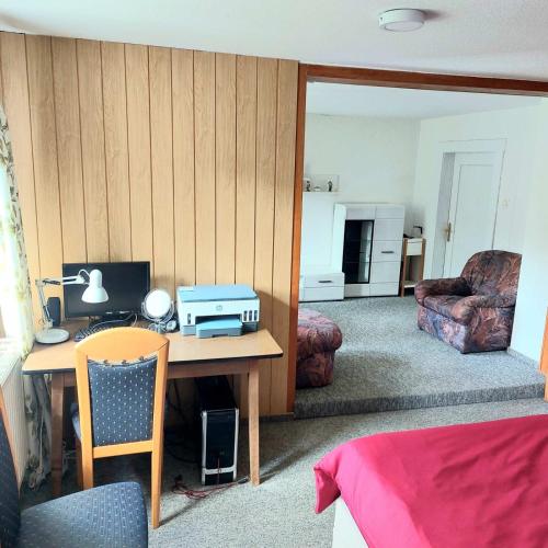 a bedroom with a desk with a printer on it at Gasthof Oberschmiede in Auf der Wiese