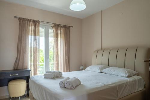 a bedroom with a bed with towels on it at Palaiologou Panorama Apartments in Mantamádos
