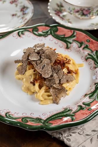 a plate of food with pasta on a table at L’Aurora in Todi