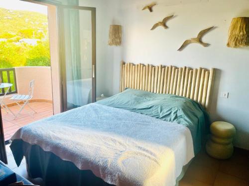 - une chambre avec un lit avec des oiseaux sur le mur dans l'établissement Villa U Castellu vue mer imprenable, à Coti-Chiavari