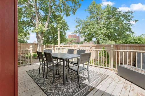 a table and chairs on a deck with a fence at City Oasis Awaits Cozy DT Home With Hot Tub Vikings in Minneapolis