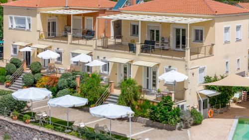 an aerial view of a building with umbrellas at Palaiologou Panorama Apartments in Mantamádos