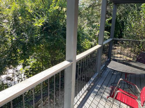 a deck with a red chair and a bench at Carr's Northside Hotel and Cottages in Gatlinburg