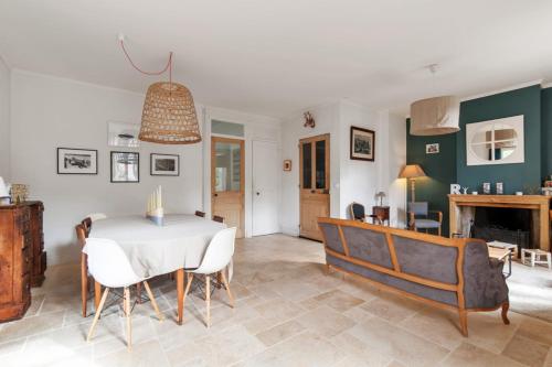 une salle à manger avec une table et des chaises blanches dans l'établissement Maison Emeraude - Welkeys, à Écully