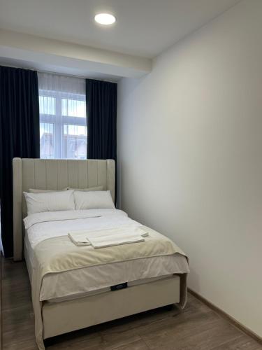 a bed in a bedroom with a window at Janjić Apartmani in Zvornik
