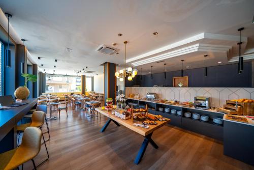 a restaurant with tables and chairs and a kitchen at Hotel J. Balmes Vic in Vic