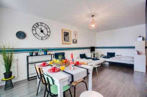 sala de estar con mesa, sillas y reloj en Appartement du Rocher - 3 étoiles - Welkeys, en Biarritz