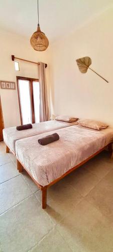 two beds in a bedroom with an umbrella on the wall at Sastro Place in Yogyakarta