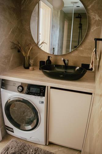 a bathroom with a sink and a washing machine at Dzintaru māja in Ģipka
