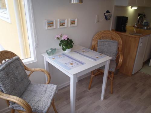 a white table with chairs and a vase of flowers on it at Oddevej 20 Skagen in Skagen